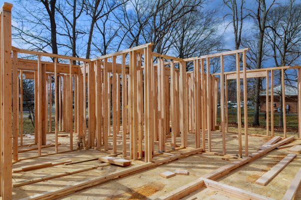 Framing structure wood frame of wooden houses home. Closeup new stick built home under construction under blue sky. real estate concept background.